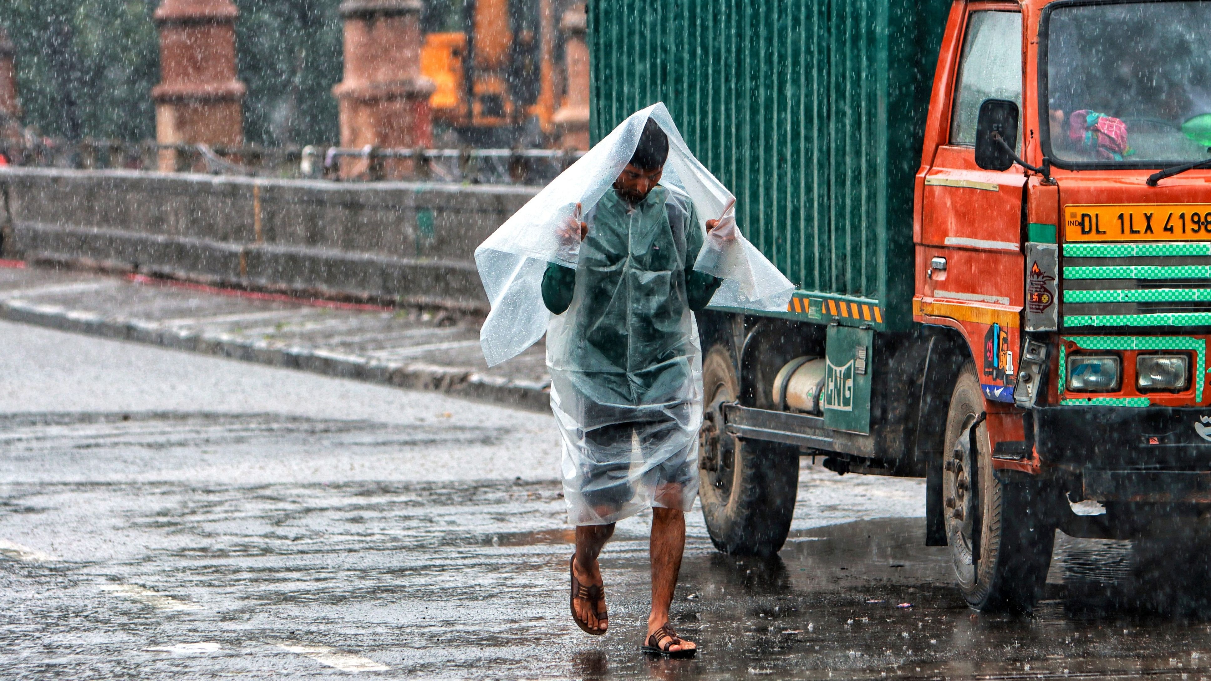 <div class="paragraphs"><p>A pedestrian uses a plastic sheet to shield himself during rains.</p></div>